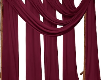 Può includere: Cinque pannelli di tessuto chiffon color borgogna drappeggiati su una cornice in legno. Il tessuto è trasparente e fluido, creando uno sfondo morbido ed elegante.