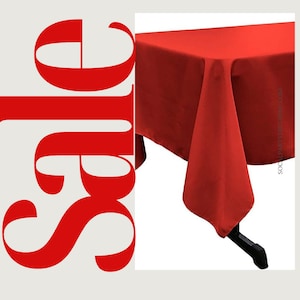 Peut inclure: Une nappe rectangulaire rouge unie. La nappe est drapé sur une table et a une surface lisse et sans plis.