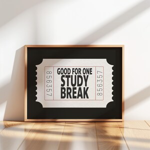 May include: A framed print with a ticket design, displaying the text "GOOD FOR ONE STUDY BREAK" in black. The ticket has a light beige background with the numbers 856357 printed on the sides. The frame is a metallic gold colour.