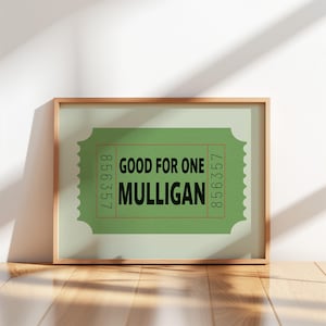 May include: A framed print featuring a green ticket design with the text "GOOD FOR ONE MULLIGAN" in black. The ticket has a light green background and a red border, with the numbers 856357 and 856357 on the sides.