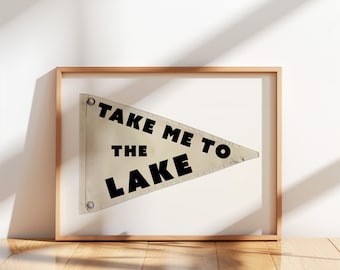 Könnte beinhalten: Eine weiße Wimpelflagge mit schwarzem Text, der "Take Me To The Lake" lautet. Die Flagge ist in einem hellen Holzrahmen gerahmt.
