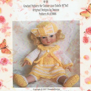 Può includere: Una bambola Tonner Ann Estelle con un completo all'uncinetto fatto a mano. Il completo comprende un vestito a righe gialle e bianche, cappello abbinato, scarpe e una giacca bianca con finiture gialle. La bambola è seduta su uno sfondo floreale. L'immagine include anche il testo "Threadsnstitches #64".