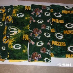 May include: Four green and yellow fleece blankets with the Green Bay Packers logo and the words "Packers" and "Pack Rus" printed on them.
