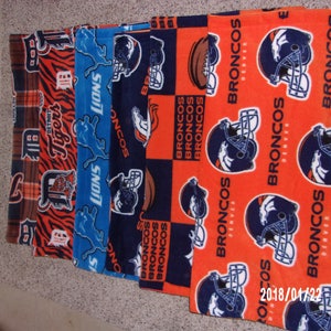 May include: Five fabric panels with different NFL team logos. The panels are orange, blue, and black with white and navy blue accents. The logos include the Detroit Tigers, the Detroit Lions, and the Denver Broncos.
