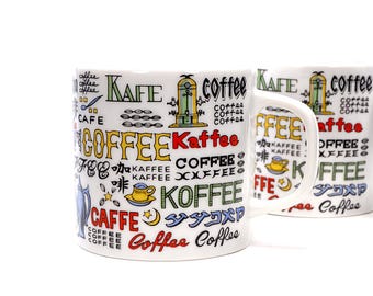 May include: White ceramic coffee mug with a colorful design featuring the words "Kaffee", "Coffee", and "Cafe" in multiple languages. The mug has a handle and is decorated with a variety of illustrations, including a coffee pot, a coffee grinder, and coffee beans.