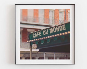 Puede incluir: Impresión enmarcada del letrero de Cafe Du Monde en Nueva Orleans. El letrero verde tiene letras blancas y pequeñas luces. El fondo muestra un edificio de ladrillo con ventanas blancas y un balcón de hierro forjado.