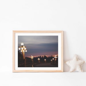 May include: A framed photograph of a bridge at dusk with streetlights illuminating the road. The sky is a gradient of purple, pink, and blue.