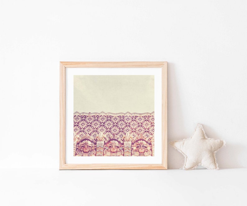 K&ouml;nnte beinhalten: Ein gerahmter Druck eines Vintage-Fotos eines Geb&auml;udes mit einer gemusterten Fassade. Das Geb&auml;ude ist mit einem sich wiederholenden Muster aus geometrischen Formen in Rosa-, Lila- und Wei&szlig;t&ouml;nen verziert. Der Druck wird an einer wei&szlig;en Wand mit einem beigefarbenen sternf&ouml;rmigen Kissen im Vordergrund gezeigt.