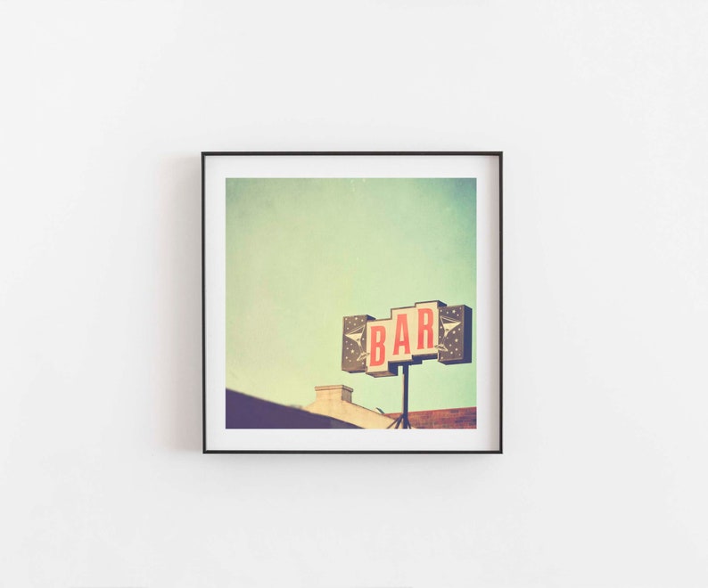 May include: A vintage photograph of a bar sign with the word "BAR" in red letters against a white background. The sign is attached to a building with a light green sky in the background.