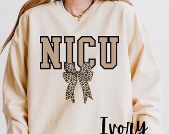 NICU ナース スウェットシャツ、コケット ヒョウ柄 リボン、トレンディなコケット シャツ、NICU ナース ギフト、NICU ナース クルーネック、ナース コケット クルーネック、NICU ナース