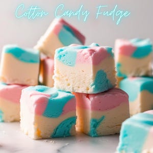 May include: A pile of cotton candy fudge cubes. The fudge features a creamy white base, swirled with pink and blue. The words "Cotton Candy Fudge" are written in a light blue script at the top of the image.