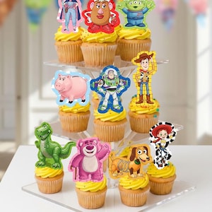 Puede incluir: Una exhibición escalonada de cupcakes adornados con figuras de personajes de la película Toy Story. Los cupcakes tienen glaseado amarillo y están dispuestos en un soporte transparente de varios niveles. Los personajes incluyen a Woody, Buzz Lightyear y otros.