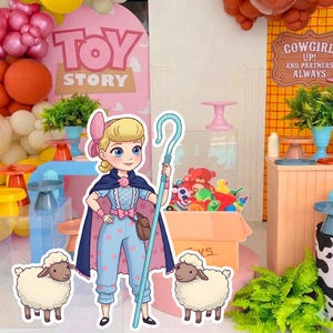 May include: A colorful Toy Story themed party decoration featuring a cartoon of Bo Peep holding a shepherd's crook, with two sheep cutouts. The background includes a Toy Story sign, balloons, and other party decorations.