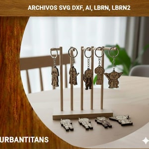 May include: Wooden keychains featuring Star Wars characters, displayed on a wooden stand. The keychains include Darth Vader, a Stormtrooper, and Yoda. The text "ARCHIVOS SVG DXF, AI, LBRN, LBRN2" is at the top, and "URBANTITANS" is at the bottom.