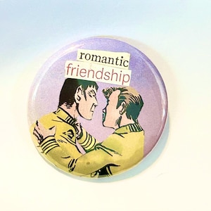 May include: A round button with a light purple background features a comic book illustration of two men in yellow shirts embracing. The words "romantic friendship" are printed in a white font on a light purple background.