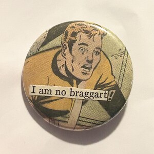 May include: Round button with a vintage comic book illustration of a man in a yellow shirt with a surprised expression. The text "I am no braggart!" is printed on the button.