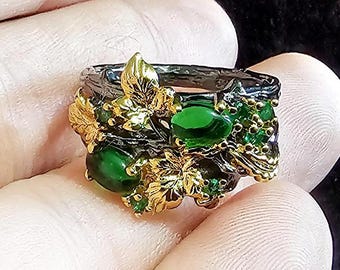 Anillo gótico con gema de hoja dorada y enredadera retorcida negra