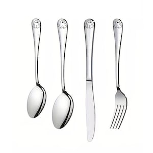 May include: A set of three silver-toned utensils with ghost designs on the handles. The set includes a spoon, a fork, and a knife.