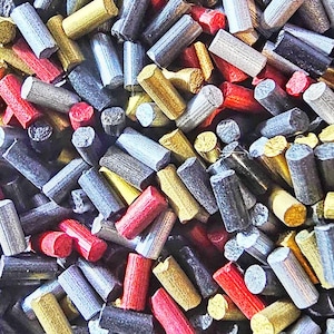 May include: A close-up shot of a pile of colorful, cylindrical objects. The objects are in various colors, including red, yellow, silver, and gray. The ends of the cylinders are flat, and the sides have a textured appearance. The objects are scattered randomly.
