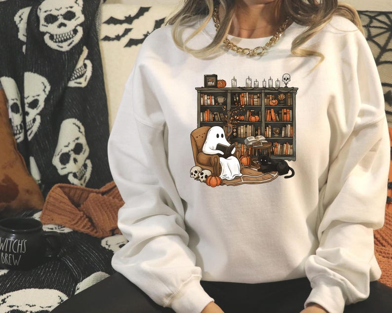 a woman sitting on a couch wearing a ghost sweatshirt