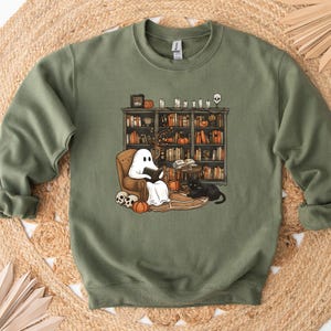 a green sweatshirt with a dog and a cat on it