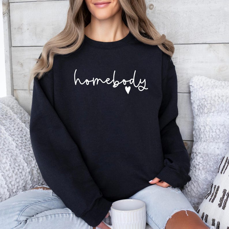 May include: A black sweatshirt with the text "homebody" in white lettering and a small white heart.