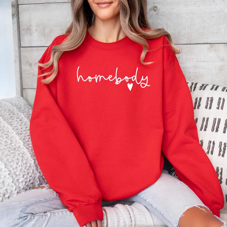 May include: Red sweatshirt with the text "homebody" in white with a small white heart.