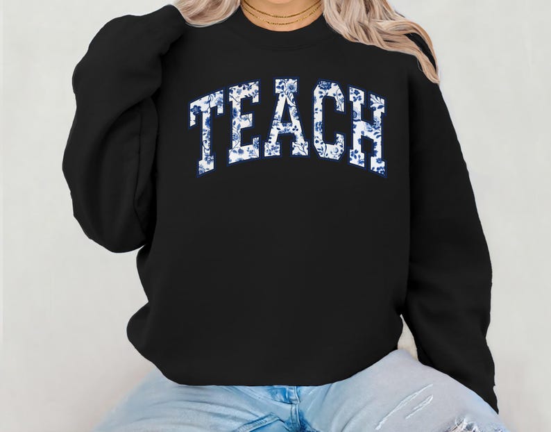 May include: Black sweatshirt with the word "TEACH" in white letters with a blue floral pattern.