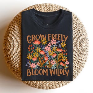 May include: Black t-shirt with a floral design and the text "Grow Freely Bloom Wildly" in orange.