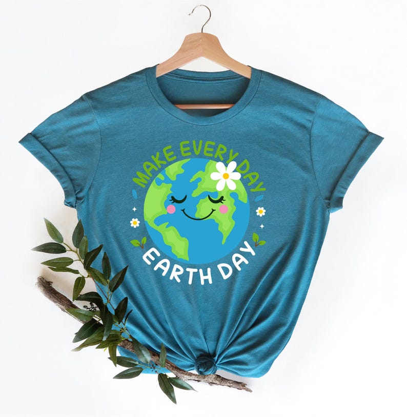 May include: Teal blue t-shirt with a graphic of a smiling cartoon Earth with a flower on top. The text "Make Every Day Earth Day" surrounds the Earth graphic.