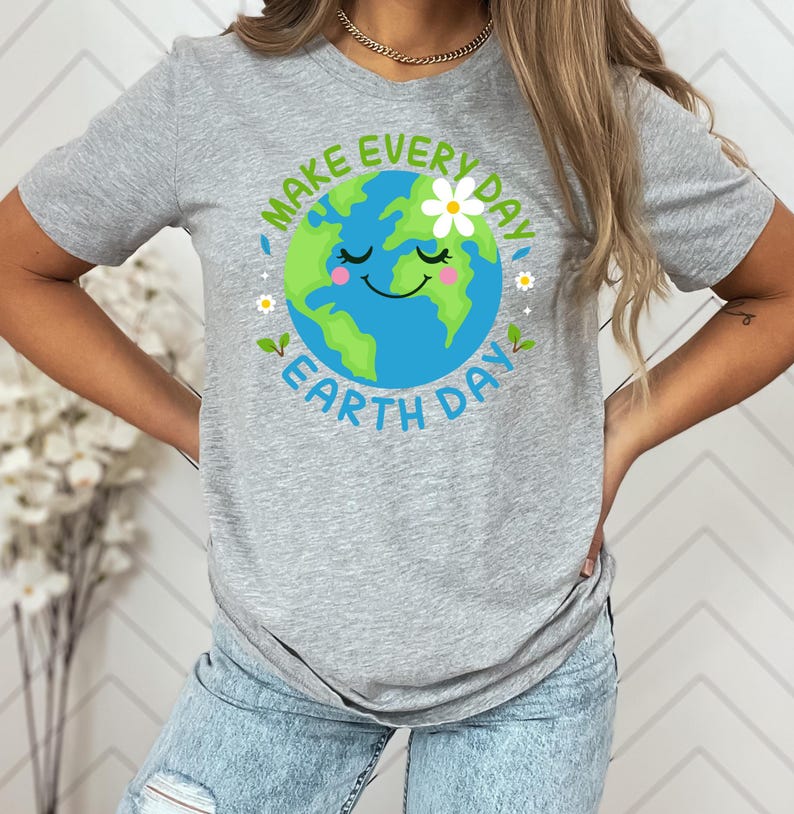 May include: Gray t-shirt with a green and blue cartoon Earth graphic. The Earth has a smiling face and a white flower on top. The text "Make Every Day Earth Day" surrounds the Earth graphic.