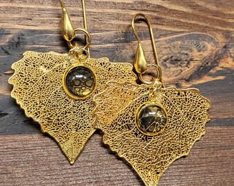 Örhängen i 24k guld med förgyllda blad och krokar i 24k sterlingsilver och dekorationer med hällkonst