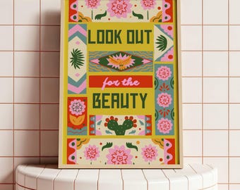May include: A framed art print with a yellow background and the words "LOOK OUT for the BEAUTY" in a colorful, decorative font. The print features floral and geometric designs in pink, green, and red.