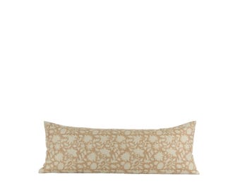 Puede incluir: Un cojín largo y rectangular con un estampado floral en beige y blanco roto. El cojín es una almohada corporal, perfecta para añadir comodidad y estilo a una cama o sofá. El diseño floral añade un toque de elegancia inspirada en la naturaleza.