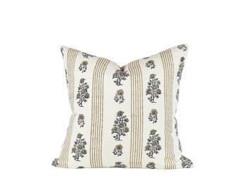 May include: A white pillow with a floral pattern and brown stripes. The flowers are in shades of green and blue.