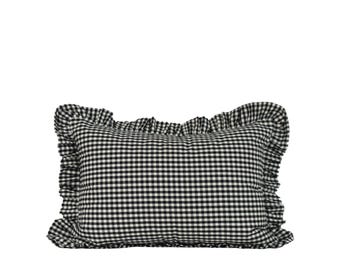 May include: A rectangular pillow with a black and white gingham pattern. The pillow has a ruffled edge, adding a decorative touch. The pillow is a classic design, suitable for various home decor styles.