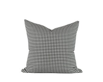 Könnte beinhalten: Schwarzes und weißes Gingham-Kissenbezug. Der Kissenbezug ist aus einem weichen, gewebten Stoff mit einem karierten Muster.
