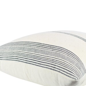 May include: White pillow cover with black stripes. The pillow cover is made of a soft, woven fabric.