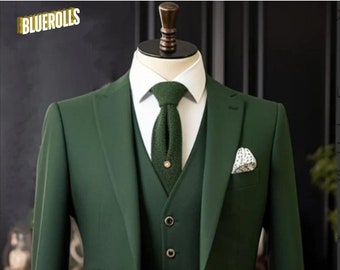 Può includere: Un abito verde scuro a tre pezzi con camicia bianca e cravatta a maglia verde scuro. Il vestito ha un fazzoletto da taschino con un motivo bianco e nero.