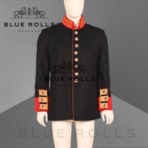 Könnte beinhalten: Eine schwarze Jacke mit roten und goldenen Verzierungen. Die Jacke hat einen hohen Kragen und eine Reihe von Knöpfen an der Vorderseite. Die Jacke wird von Blue Rolls Bespoke hergestellt.