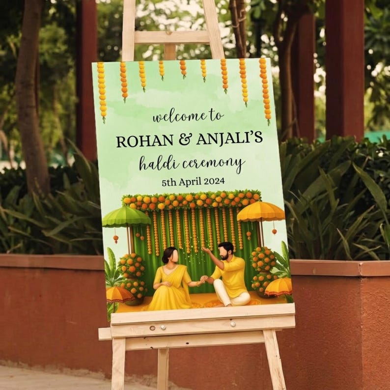 May include: A wooden easel displays a sign with the text "welcome to ROHAN & ANJALI'S haldi ceremony 5th April 2024." The sign features a watercolor illustration of a couple in yellow attire, with floral and umbrella decorations.