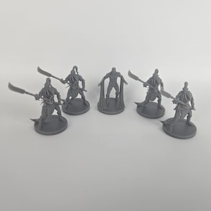 May include: A collection of gray miniature figurines, likely for tabletop gaming. The figures include warriors with large curved blades and a central figure with outstretched arms. The figures are on circular bases.