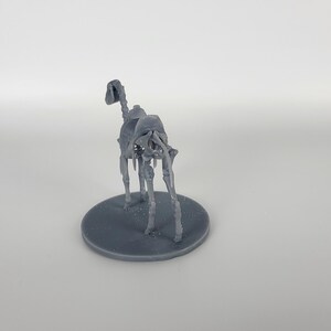 May include: A gray 3D printed miniature of a skeletal horse, standing on a round base.