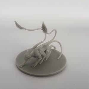 以下が含まれることがあります： 長い細い尻尾と4本の脚を持つ生き物のグレーの3Dプリントミニチュア。生き物はしゃがみこんだ姿勢で、頭を下げている