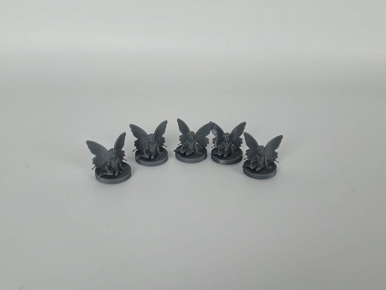 May include: Five gray miniature fairy figurines with wings, each sitting on a round base.
