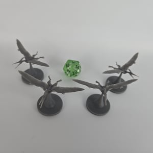 May include: Four gray miniature pterodactyl figurines with outstretched wings and a green 20-sided die. The figurines are on circular bases. The die is translucent green with white numbers.