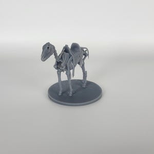 May include: A gray plastic miniature of a horse skeleton with a saddle on its back. The skeleton is standing on a round gray base.