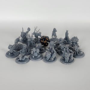 May include: A collection of 17 gray 3D printed miniature figurines, including a deer, a mushroom creature, and several small creatures with large ears. A black 20-sided die is in the center of the image.