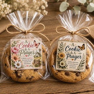 May include: Two chocolate chip cookies individually wrapped in clear plastic bags tied with brown twine. Each bag features a square tag with the text A Cookie & A Prayer, floral illustrations, and a butterfly, one with a barn and windmill.