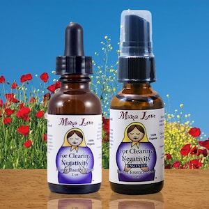 May include: Two amber glass bottles of Mama Love flower essence blend. One has a dropper, the other a spray top. Each bottle has a label with a Matryoshka doll design and the text "For Clearing Negativity". The background features red flowers.